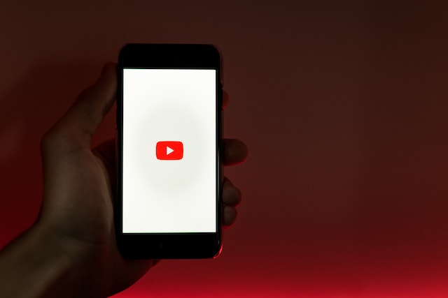 dłoń trzymająca iphona z włączoną aplikacją youtube