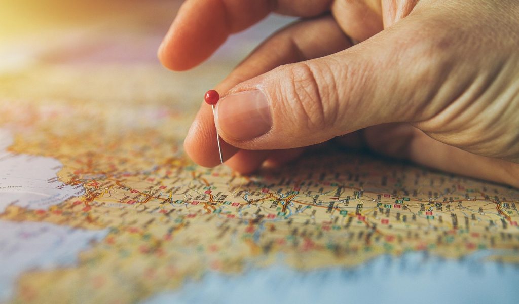 Czerwona pinezka wbita w mapę wskazuje konkretną lokalizację.