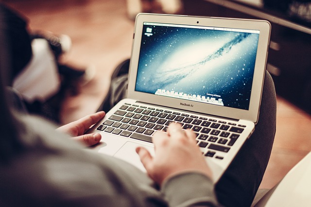 laptop na kolanach